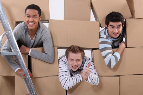 House removal team carrying furniture through a narrow apartment access point
